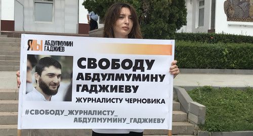 Журналист "Черновика" Инна Хатукаева держит плакат с портретом Абдулмумина Гаджиева. Фото Патимат Махмудовой для "Кавказского узла" 