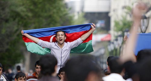 Мужчина держит флаг Азербайджана. Фото: REUTERS/David Mdzinarishvili
