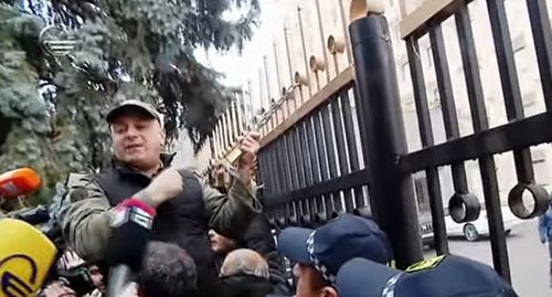 Сторонники оппозиции в Тбилиси повесили символический замок на ограду здания правительства. Стоп-кадр видео канала YouTube "TV IMEDI" https://www.youtube.com/watch?v=dgm7LXcNjn0