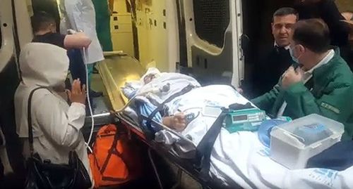 Огтая Гюльалыева, который находится в критическом состоянии после ДТП, заносят в машину скорой помощи. Стоп-кадр видео YouTube канала Turan Agentliyi https://www.youtube.com/watch?v=cBrdMD4gSkk