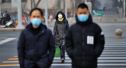 Люди в медицинских масках в Китае. Фото: REUTERS/Carlos Garcia Rawlins