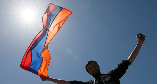 Мужчина держит флаг Армении. Фото: REUTERS/Gleb Garanich