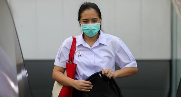 Девушка в медицинской маске. Фото REUTERS/Athit Perawongmetha