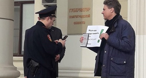 Александр Ефимов в одиночном пикете общается с сотрудниками полиции. Фото Татьяны Филимоновой для "Кавказского узла"