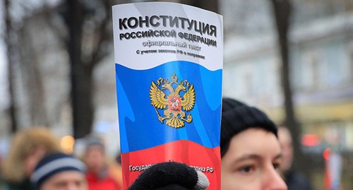 Участник акции протеста держит Конституцию Российской Федерации. Фото: REUTERS/Tatyana Makeyeva