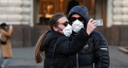 Прохожие в медицинский масках. REUTERS/Evgenia Novozhenina