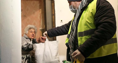Волонтер передает сумки с едой и напитками  во время  вспышки коронавирусной болезни (COVID-19) в Тбилиси, Грузия, 18 марта 2020 года. REUTERS/Ираклий Геденидзе