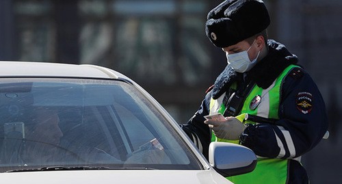 Сотрудник полиции проверяет документы у водителя. Санкт-Петербург, 31 марта 2020 г. Фото: REUTERS/Anton Vaganov