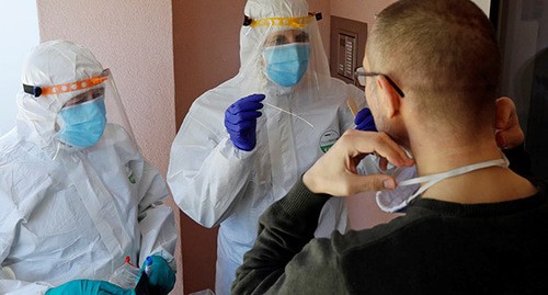 Медицинские работники в защитной одежде тестируют пациента на коронавирус. Фото: REUTERS/David W Cerny