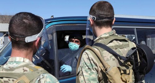 Грузинские военнослужащие беседуют с водителем на контрольно-пропускном пункте, после того как власти ужесточили меры по предотвращению распространения коронавирусной болезни. Фото  REUTERS/Ираклий Геденидзе