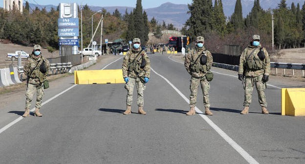 Грузинские военнослужащие в защитных масках на посту  в Марнеули близ Тбилиси, Грузия. Фото:иREUTERS/Irakli Gedenidze/