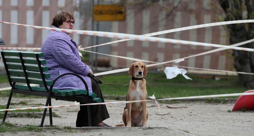 Женщина гуляет с собакой во дворе дома. Фото: REUTERS/Evgenia Novozhenina