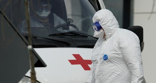 Медицинский сотрудник в защитном костюме возле машины скорой помощи. Фото: REUTERS/Tatyana Makeyeva