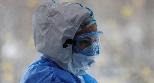 Медик в защитном костюме. Фото REUTERS/Maxim Shemetov
