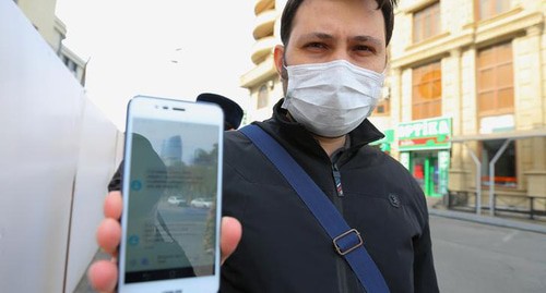 Житель Баку предъявляет пропуск. Фото REUTERS/Aziz Karimov