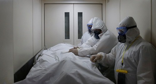 Медицинские работники в защитных костюмах осматривают пациента. Май 2020 г. Фото: REUTERS/Maxim Shemetov