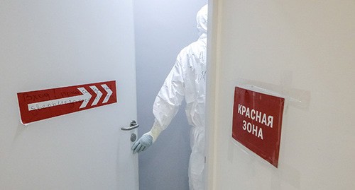 Медицинский работник открывает дверь с надписью "Красная зона". Фото: Sofya Sandurskaya/Moscow News Agency/Handout via REUTERS 