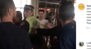 Участник уличной вечеринки толкает сотрудника полиции. Кадр видео, опубликованного в Instagram-паблике "Туподар" https://www.instagram.com/p/CBIHbq-gKWu/