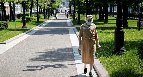 Пожилая женщина в защитной маске во время прогулки. Фото: REUTERS/Shamil Zhumatov