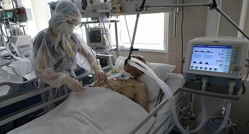 Медицинский работник возле пациента. Фото: Andrei Nikerichev/Moscow News Agency/Handout via REUTERS