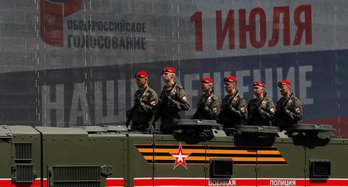Российские военные проезжают мимо электронного экрана с рекламой голосования о конституционных изменениях во время репетиции парада Победы в Москве. Фото: REUTERS/Maxim Shemetov
