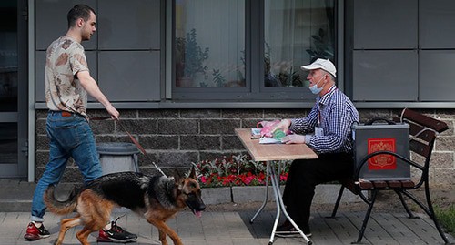Член местной избирательной комиссии беседует с человеком с собакой на открытом избирательном участке. Июнь 2020 г. Фото: REUTERS/Anton Vaganov