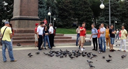 Жители Астрахани кормят голубей на площади и выражают поддержку хабаровчанам. Астрахань, 2 августа 2020 года. Фото Алены Садовской для "Кавказского узла".