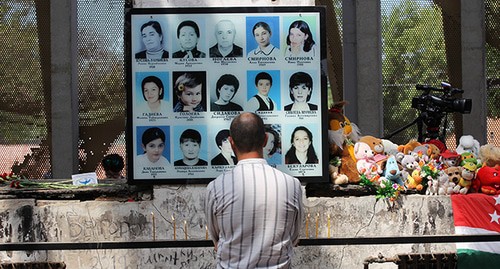 Мужчина возле портретов детей, погибших в школе.  Беслан, 3 сентября 2020 г. Фото Тамары Агкацевой для "Кавказского узла"
