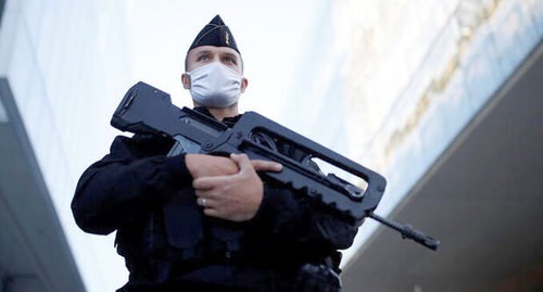 Полицейский в защитной маске стоит возле здания суда в Париже, Франция, 2 сентября 2020 года. Судебный процесс пройдет со 2 сентября по 10 ноября. REUTERS/Christian Hartmann