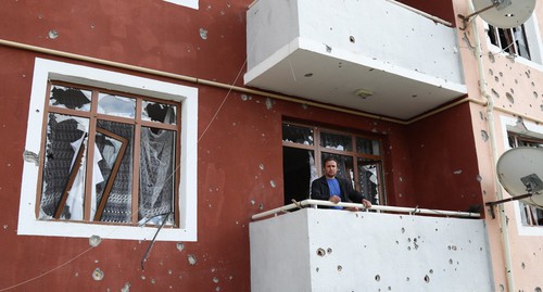 Мужчина на балконе обстрелянного здания. Фото Азиза Каримова для "Кавказского узла"