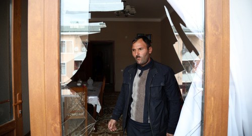 Мужчина в разбитом обстрелом окне, Гянджа, октбярь 2020 года. Фото Азиза Каримова для "Кавказского узла"