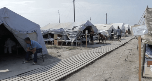 Люди у палаток во временном пункте размещения близ Куллара. Кадр видео "Кавказского узла".