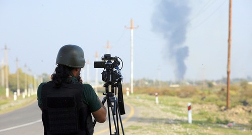 Журналист снимает дым от пожара после обстрела азербайджанского села Агдам, 19.10.20.  Фото Азиза Каримова для "Кавказского узла"