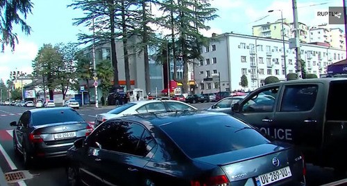 Полицейские машины на месте ограбления банка в Зугдиди. Стоп-кадр видео https://russian.rt.com/ussr/video/794790-gruziya-zahvat-zalozhnikov-bank