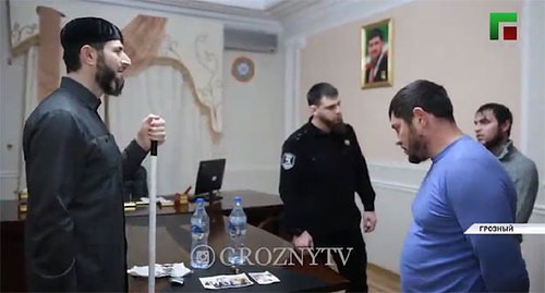 Главный специалист Центра исламской медицины Адам Эльжуркаев отчитывает задержанных в присутствии сотрудника силовой структуры. Кадр видео ЧГТРК "Грозный" https://www.instagram.com/p/CI7pCFNJclV/