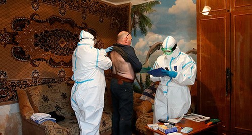 Медицинские работники проверяют здоровье пациента в его доме. Декабрь 2020 года. Фото: REUTERS/Anton Vaganov