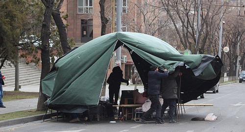 Участники акции удерживают палатку, чтобы не унес ветер. Ереван, 12 марта 2021 г. Фото Тиграна Петросяна для "Кавказского узла"