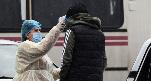 Медицинский работник измеряет температуру. Фото: Hayk Baghdasaryan/Photolure via REUTERS