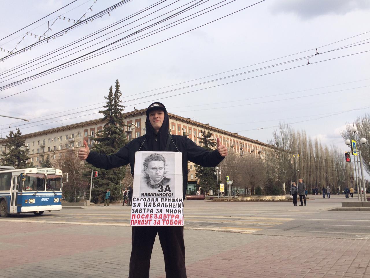 Прохожий с плакатом пикетчиков в Волгограде. 3 апреля 2021 года. Фото Татьяны Филимоновой для "Кавказского узла".