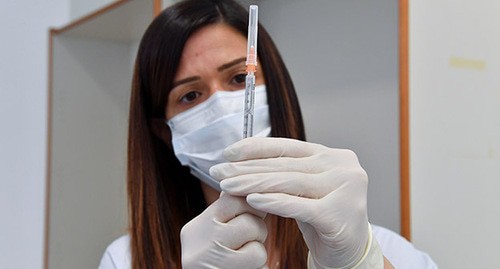 Медицинский работник держит шприц с вакциной перед прививкой. Фото: REUTERS/Jennifer Lorenzini