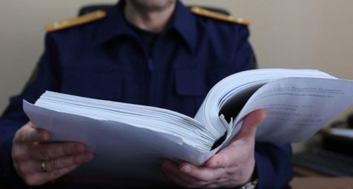 Сотрудник полиции изучает уголовное дело. Фото Елена Синеок, "Юга.ру"