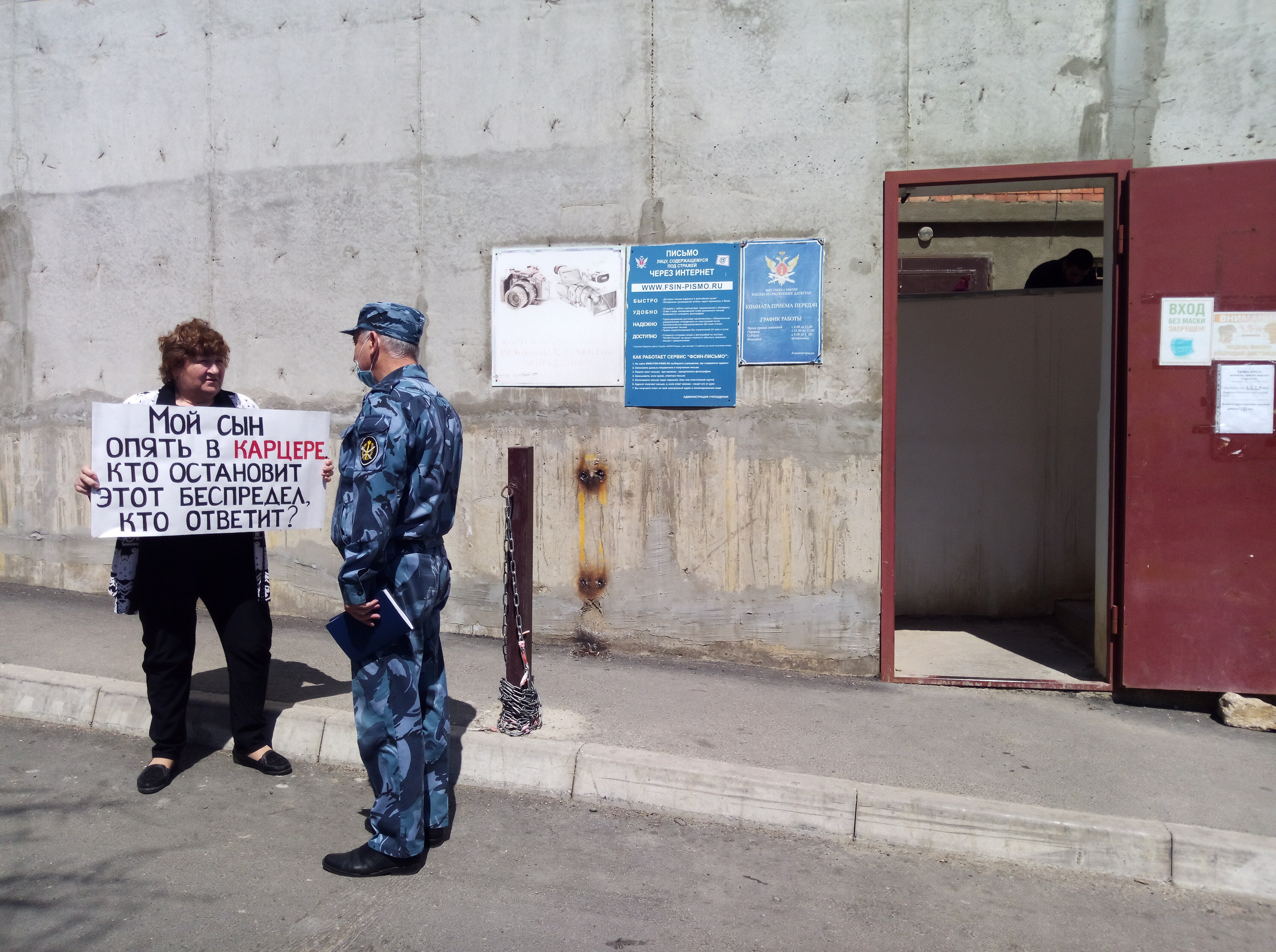 Сотрудник СИЗО подходит к Елене Барзукаевой во время пикета в Махачкале 8 мая 2021 года. Фото Расула Магомедова для "Кавказского узла"