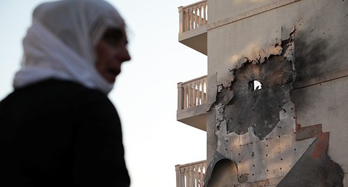Женщина на фоне разрушенного здания в Сирии. Фото: REUTERS/Sertac Kayar