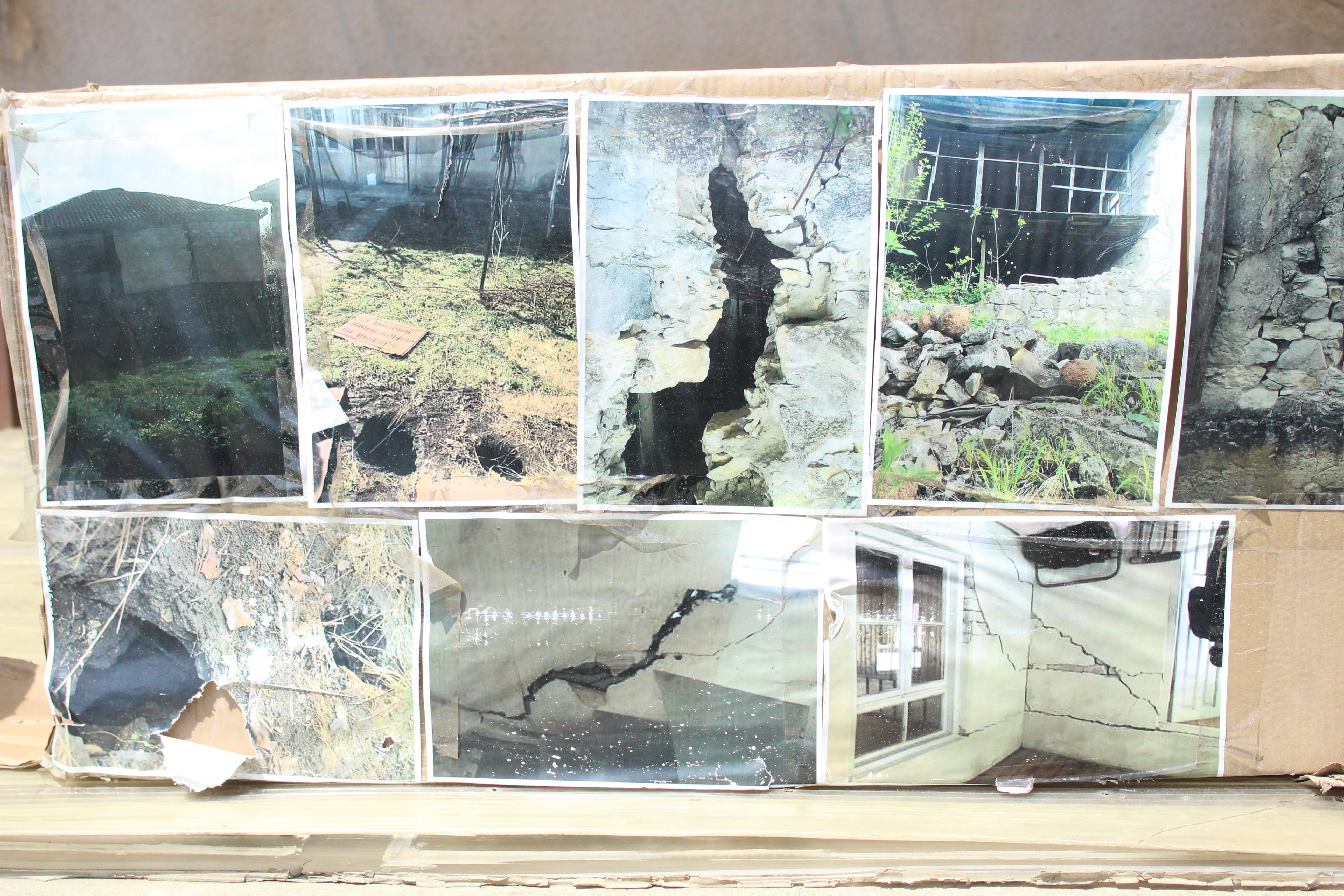 Фото поврежденных домов в селе Шукрути, выставленные участниками голодовки в Тбилиси. 5 июня 2021 года. Фото Инны Кукуджановой для "Кавказского узла"