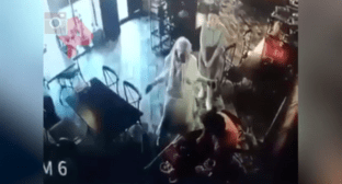 Конфликт между Элезом Мержоевым (в оранжевой одежде) и Айной Гетагазовой (в белом) в назранском кафе 15 июня 2021 года. Стоп-кадр видео https://dni.ru/video/2021/6/17/481045.html