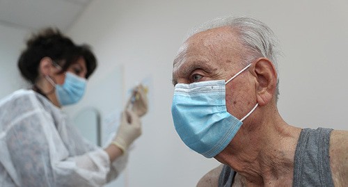 Пожилой человек перед прививкой от COVID. Фото: REUTERS/Irakli Gedenidze