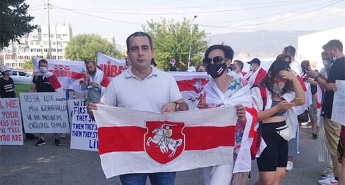 Егор Куроптев и одна из участниц митинга держат флаг. Фото Беслана Кмузова для "Кавказского узла"