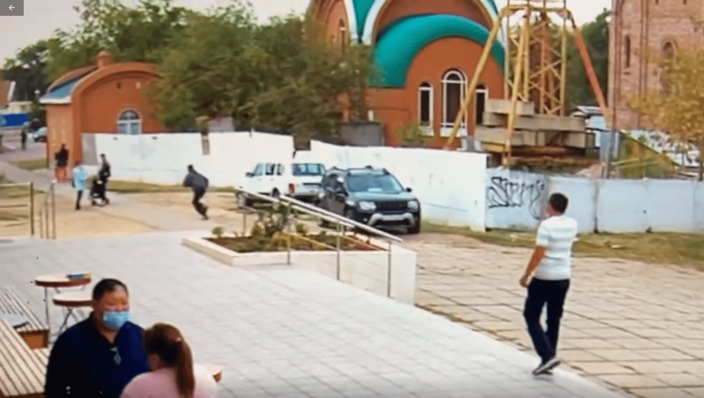 Человек, проколовший колесо машины Санала Очирова (черное авто в центре), убегает с места происшествия. Стоп-кадр видео, предоставленного "Кавказскому узлу" Саналом Очировым.