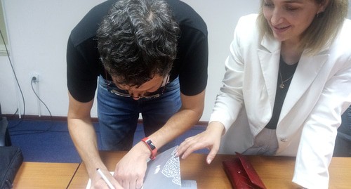 Писатель Владимир Севриновский подписывает свою книгу читателю. 20 сентября 2021г. Фото Расула Магомедова для "Кавказского узла"