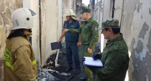 Сотрудник спецслужб при пожаре в Хасавюрте. Фото пресс-службы СК России